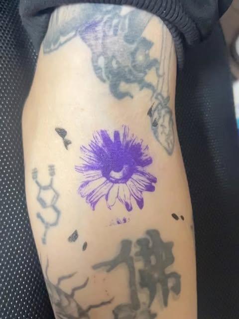 Tatouage floral violet réalisé par Kaopy Gasy